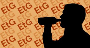 A silhouette of a person drinking from a bottle.