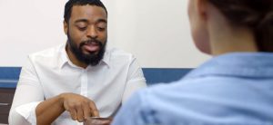 A man sitting at a table with another person.