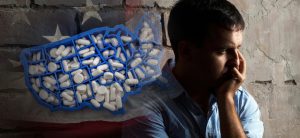 A man sitting in front of an american flag.