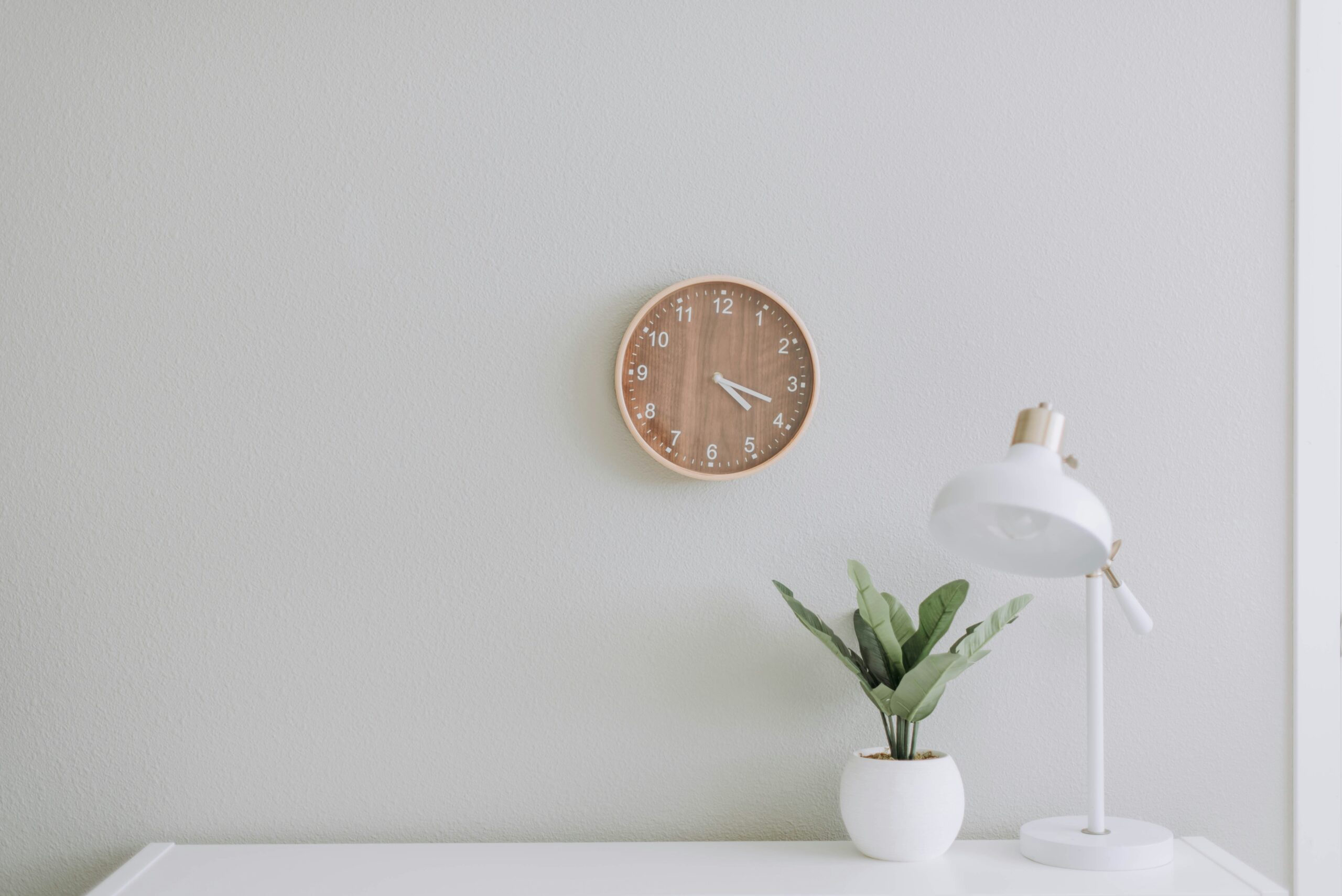 A clock on the wall above a table