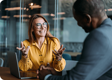 Two people smiling and laughing in a meeting